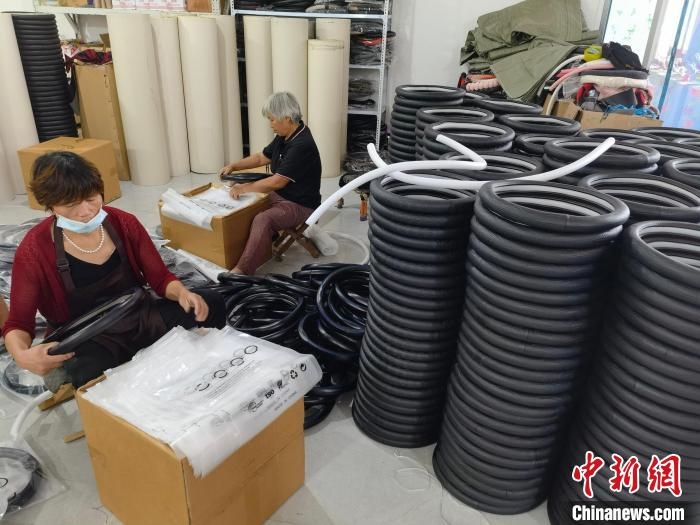 圖為村民在汽車飾品企業(yè)生產(chǎn)車間中工作?！巫雍?攝