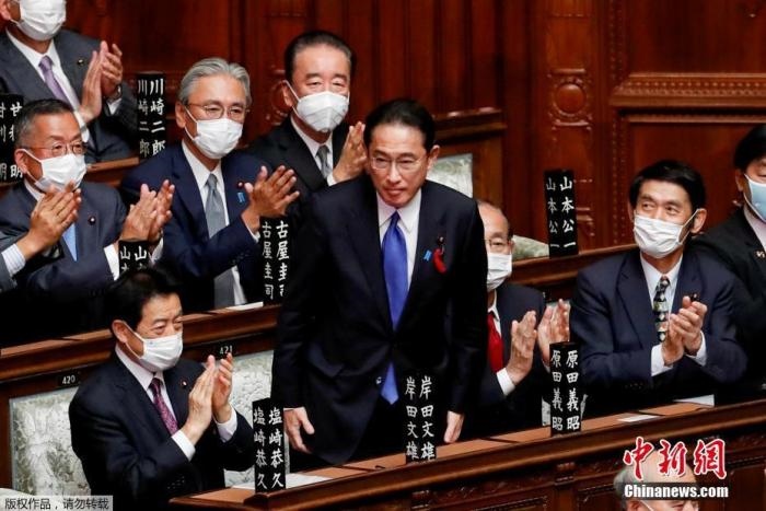 當?shù)貢r間10月4日，日本自民黨總裁岸田文雄經(jīng)過眾院全體會議的首相指名選舉成為第100任首相。圖為岸田文雄（中）起身致謝。