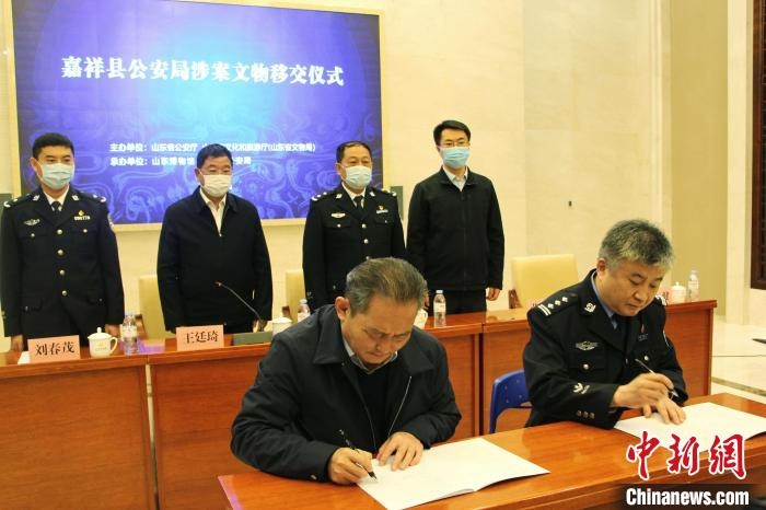 山東博物館館長(zhǎng)鄭同修和嘉祥縣人民政府副縣長(zhǎng)、公安局局長(zhǎng)趙健簽署移交協(xié)議?！≮w曉 攝