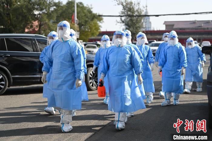 圖為醫(yī)務(wù)人員在封閉小區(qū)做防控工作?！⑽娜A 攝