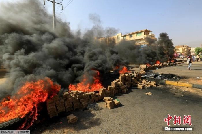 當?shù)貢r間10月25日，蘇丹局勢發(fā)生突變，過渡政府總理被“綁架”，政府部長被軍方抓捕，國家進入緊急狀態(tài)，大量民眾走上街頭對軍方行動進行抗議，已有7人在抗議活動中死亡，140人受傷。圖為抗議活動中燃燒的輪胎。