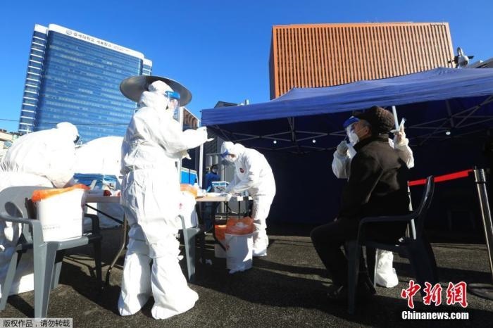 資料圖：韓國首爾，醫(yī)務(wù)人員對市民進行新冠病毒檢測。