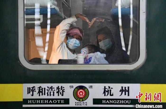 圖為登上轉(zhuǎn)運(yùn)火車的游客向額濟(jì)納比心?！⊥趵?攝