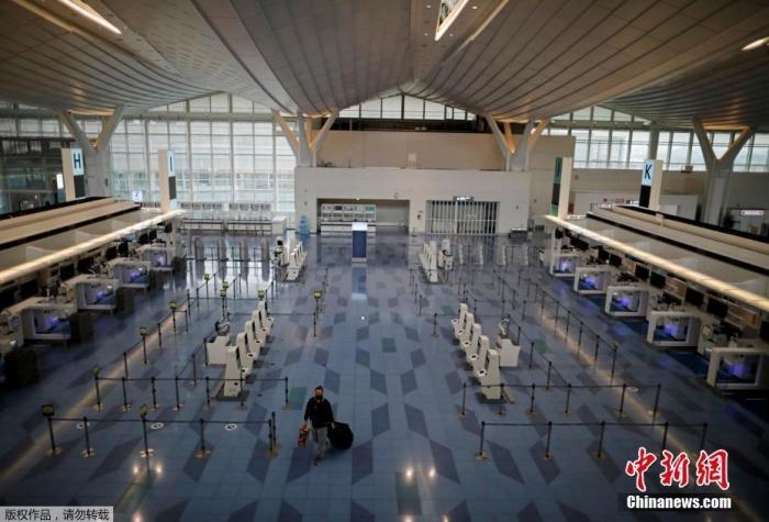 資料圖：日本東京，東京國際機(jī)場，一名乘客在國際航班航站樓的登機(jī)區(qū)。