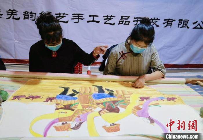 圖為皮繡藝人在市集上“秀”指尖技藝?！●R銘言 攝