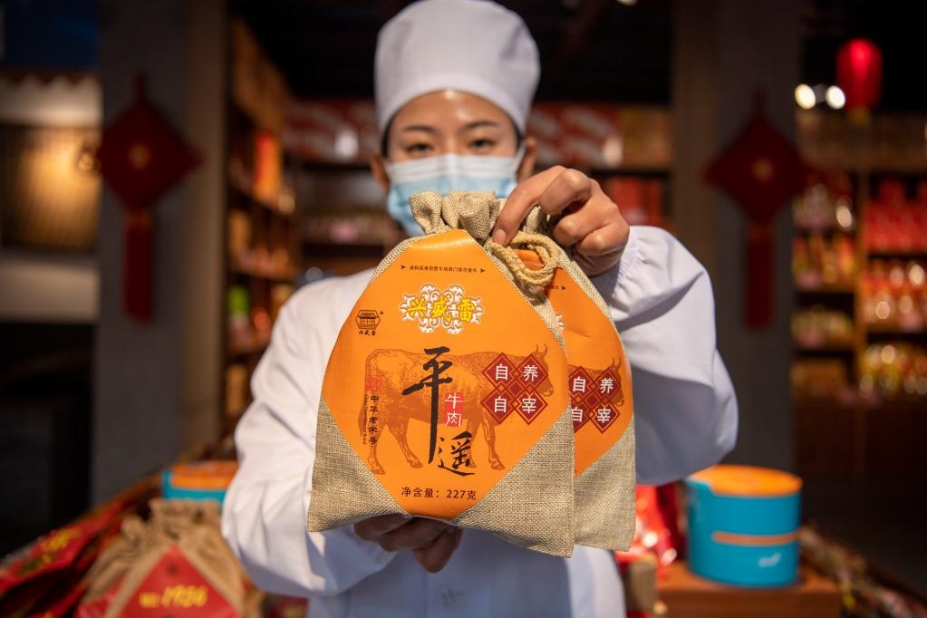 1月27日，在平遙古城南大街的一家平遙牛肉店內(nèi)，工作人員展示一款牛肉產(chǎn)品。新華社記者 楊晨光 攝