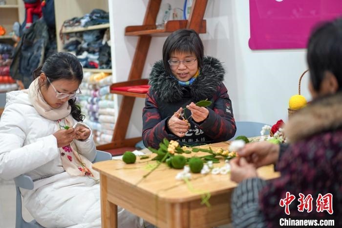 文創(chuàng)工作室的姐妹們正在鉤織月桂葉片。　古良駒 攝