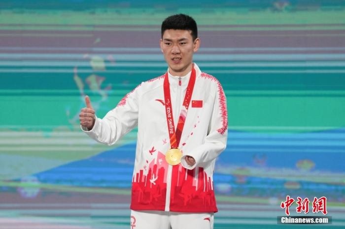 3月6日，梁景怡在延慶頒獎廣場領(lǐng)獎臺上豎起大拇指。當(dāng)日，在國家高山滑雪中心舉行的北京2022年冬殘奧會殘奧高山滑雪男子超級大回轉(zhuǎn)—站姿決賽中，中國選手梁景怡奪得冠軍。 <a target='_blank' href='/'>中新社</a>記者 楊華峰 攝