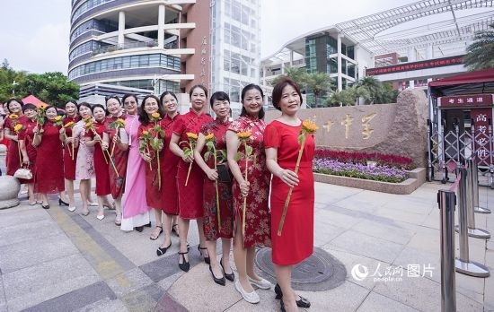 6月7日一早，廈門雙十中學考生家長們身穿旗袍，手拿向日葵在考場外為孩子加油打氣，寓意“旗開得勝，一舉奪魁”。人民網記者 陳博攝