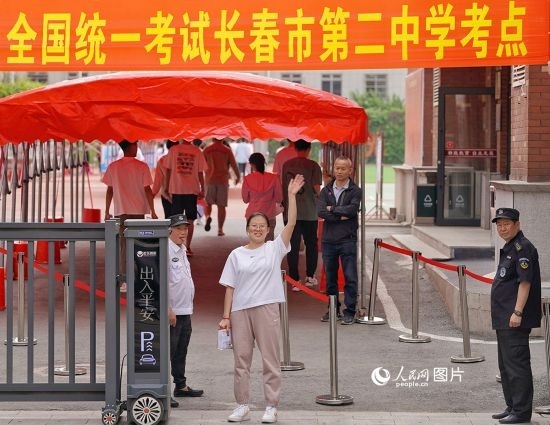 6月7日，在長春市第二中學考點，一名考生信心滿滿進入考場，并與家長揮手致意。人民網記者 李洋攝