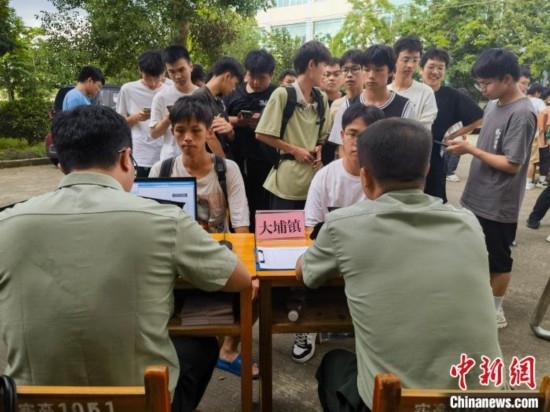 專武干部在發(fā)放兵役登記證。韋碩 攝