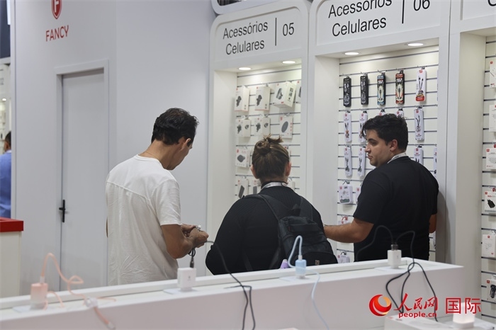 幾名參觀(guān)者在一個(gè)展臺(tái)前了解手機(jī)配件。（人民網(wǎng)記者 時(shí)元皓攝）