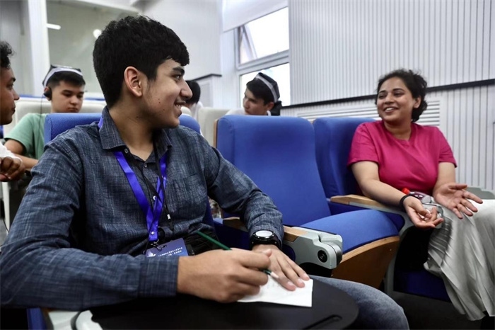 “上合小記者”在中國傳媒大學外語學院采訪留學生。中新社供圖