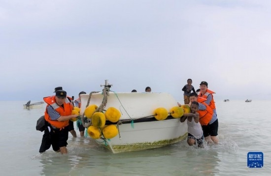 7月21日，中國海軍“和平方舟”號醫(yī)院船醫(yī)護人員涉水登島，前往基里巴斯一診療點。新華社記者 黎云 攝