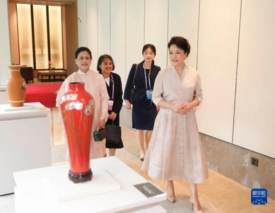 7月27日下午，國(guó)家主席習(xí)近平夫人彭麗媛在四川成都會(huì)見(jiàn)陪同印度尼西亞總統(tǒng)佐科來(lái)華出席第31屆世界大學(xué)生夏季運(yùn)動(dòng)會(huì)開(kāi)幕式并訪華的總統(tǒng)夫人伊莉亞娜。這是彭麗媛和伊莉亞娜欣賞成都特色非遺工藝品。新華社記者 丁林 攝