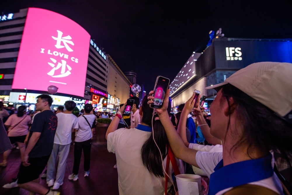  游客在長(zhǎng)沙市天心區(qū)黃興路步行街打卡、拍照（6月7日攝）。新華社記者 陳思汗 攝