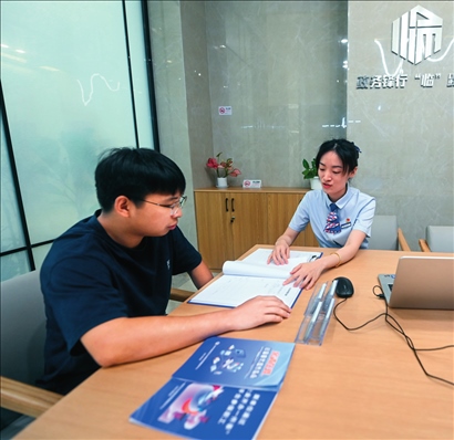 在杭州市臨安區(qū)政務(wù)服務(wù)中心的“為企服務(wù)中心”，黨員志愿者（右）解答企業(yè)主的疑問（2023年7月7日攝）。徐昱攝/本刊