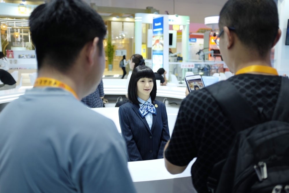 9月1日，媒體記者在國家會(huì)議中心與服務(wù)機(jī)器人互動(dòng)。新華社記者 劉夢(mèng)琪 攝