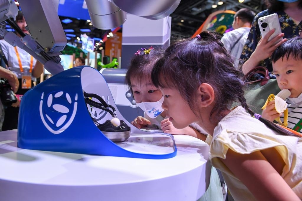 9月3日，幾名小朋友在國家會(huì)議中心觀看單孔腔鏡手術(shù)機(jī)器人展示。新華社記者 鞠煥宗 攝