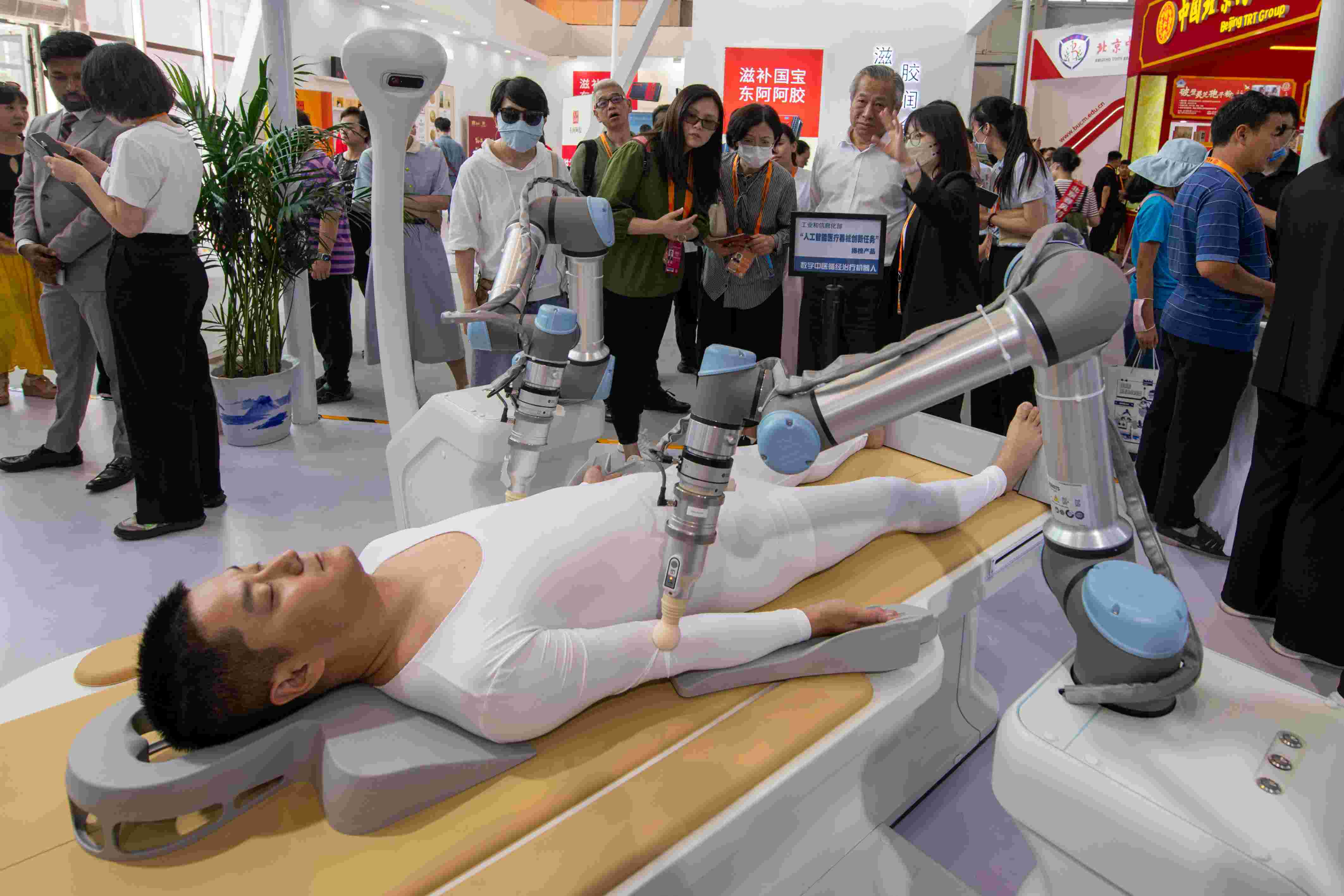 在位于首鋼園的健康衛(wèi)生服務(wù)展區(qū)，觀眾正在參觀數(shù)字中醫(yī)循經(jīng)治療機器人。人民網(wǎng)記者 翁奇羽攝
