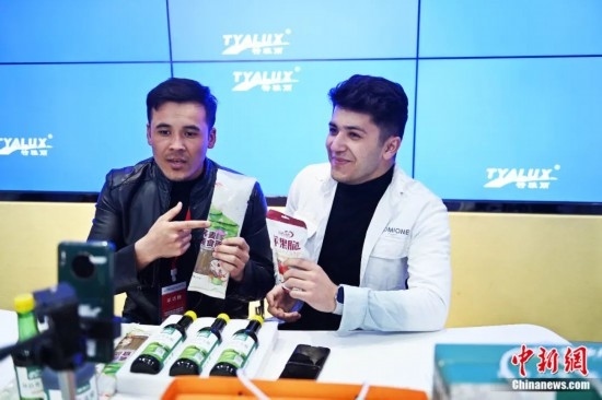 2023年3月，甘肅省慶陽市環(huán)縣電商創(chuàng)業(yè)孵化基地內(nèi)，來自蘭州文理學院的塔吉克斯坦留學生正在協(xié)助主播直播帶貨當?shù)剞r(nóng)特產(chǎn)品。李亞龍 攝