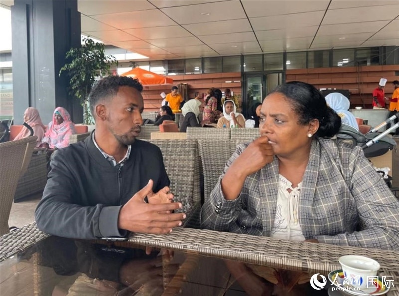 約漢斯（圖左）與德貝拉在友誼廣場(chǎng)咖啡廳交談。人民網(wǎng)記者 趙艷紅攝