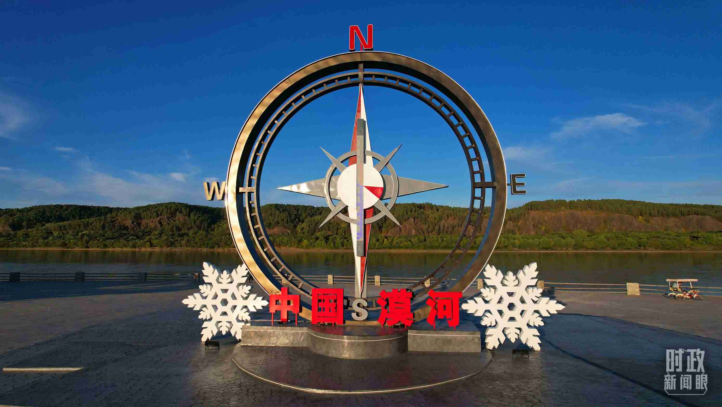 △指北針雕塑是北極村標志性建筑之一，其紅色指針指向正北方。上面的大型溫度計高12.22米，象征北極村位于東經(jīng)122°20′。（總臺央視記者范凱拍攝）