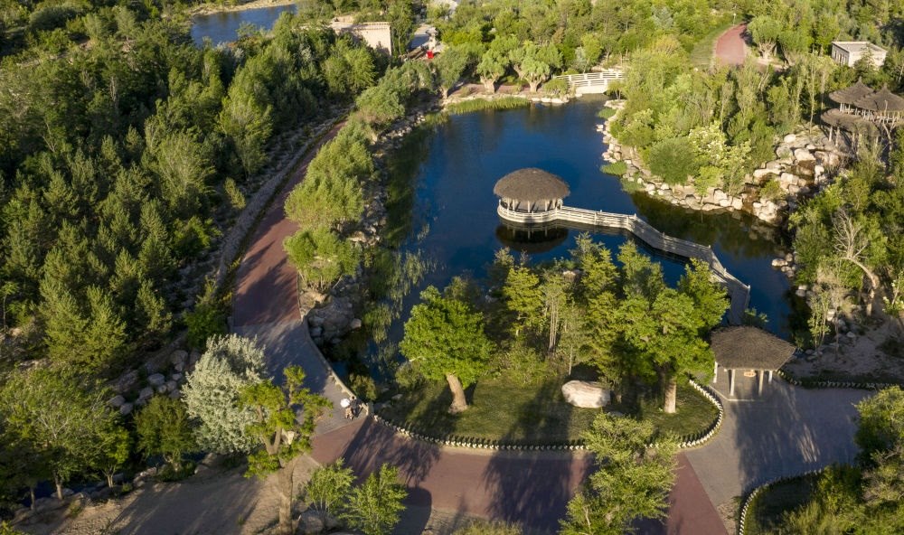 坐落在寧夏銀川市賀蘭山腳下的賀蘭山運(yùn)動(dòng)休閑公園（2021年5月27日攝，無(wú)人機(jī)照片）。這里曾是一片砂石采礦塌陷區(qū)，當(dāng)?shù)赝ㄟ^(guò)植被景觀再造、水系建設(shè)、現(xiàn)代管網(wǎng)鋪建等手段，重新利用廢石、廢坑及各類廢棄建筑材料，把這里變成一座免費(fèi)開(kāi)放的主題公園。新華社記者 馮開(kāi)華 攝