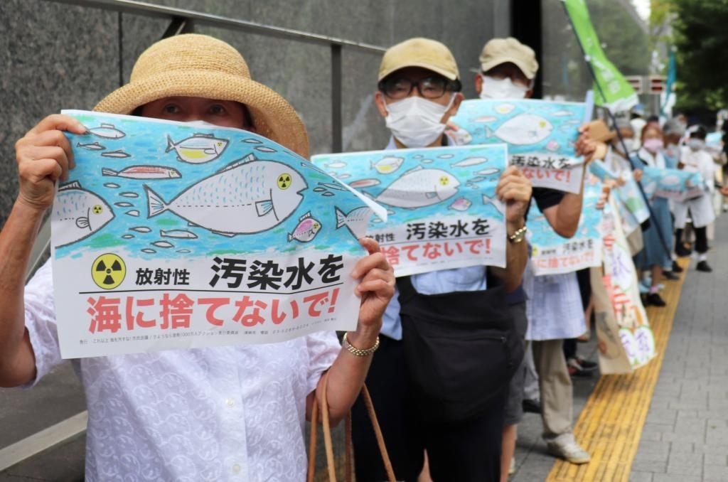 8月24日，日本民眾手持“不要將污染水扔進大?！钡葮苏Z在東京電力公司總部前集會，抗議日本政府和東電公司無視民意啟動核污染水排海。新華社記者楊光攝