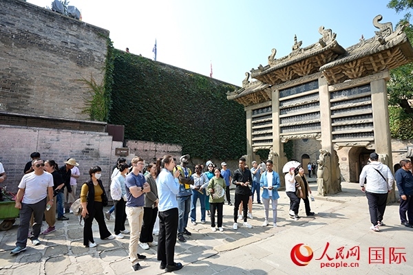 選手們認(rèn)真聆聽導(dǎo)游講解。人民網(wǎng) 盧鵬宇攝