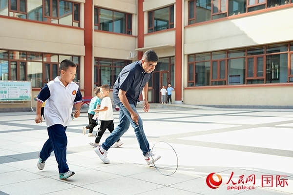 來(lái)自巴基斯坦的沙杰在滾鐵環(huán)。人民網(wǎng) 盧鵬宇攝