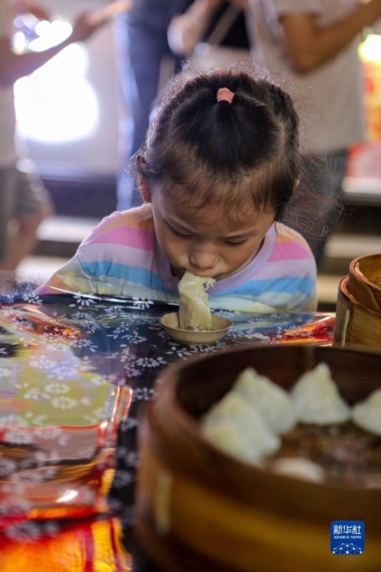 9月27日，小朋友在南翔小籠長街宴上品嘗南翔小籠。