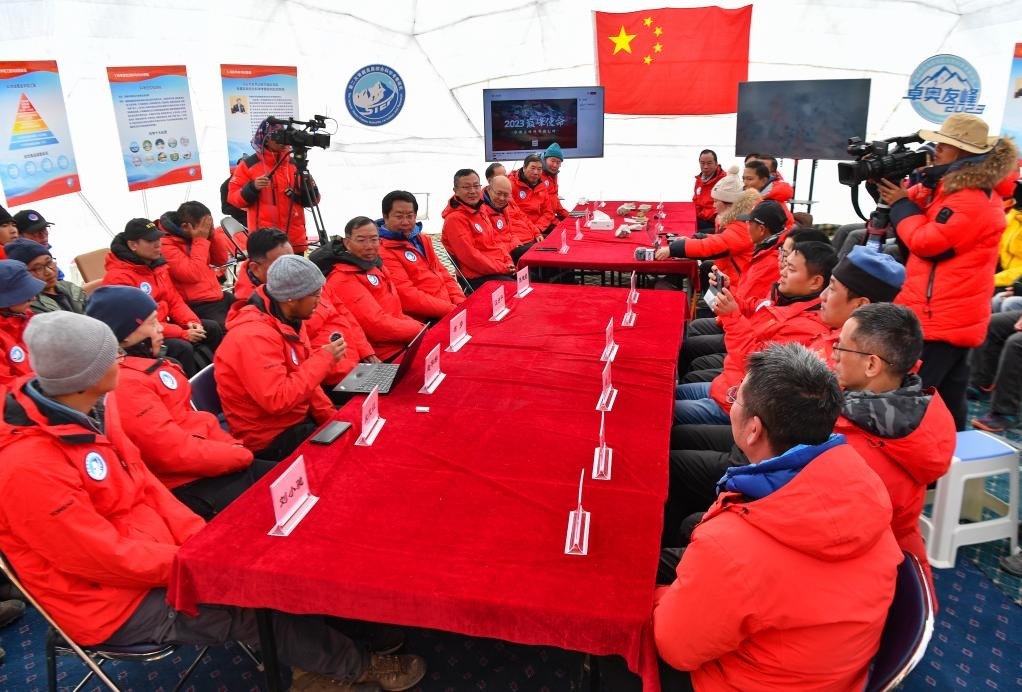 海拔4950米的卓奧友峰科考大本營，科考隊員趙華標(biāo)（手拿麥克風(fēng)看電腦者）在宣讀剛剛接收到的頂峰氣象觀測數(shù)據(jù)，這標(biāo)志著峰頂自動氣象站架設(shè)成功，成功傳回觀測數(shù)據(jù)（10月1日攝）。新華社記者晉美多吉 攝