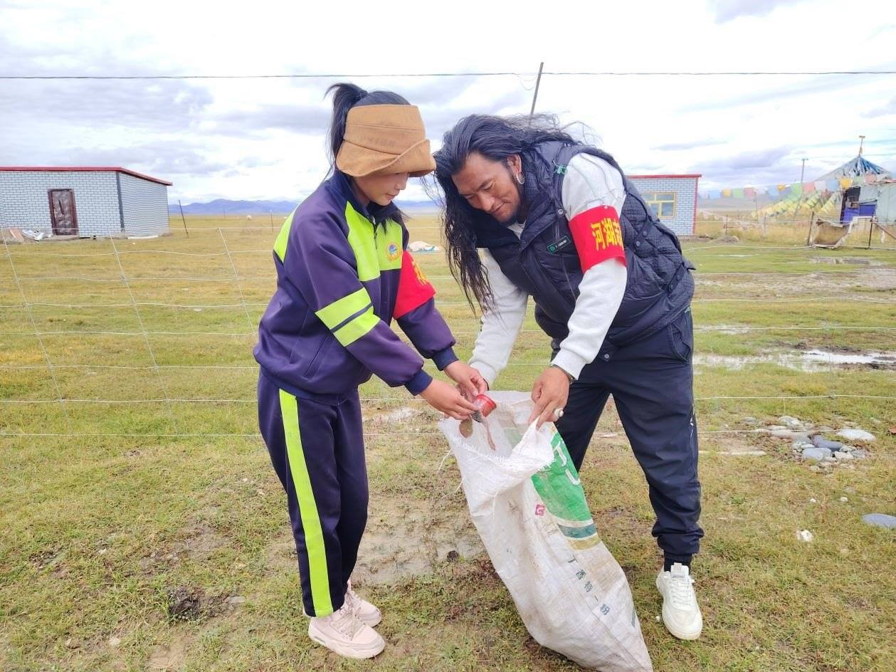 玉樹州稱多縣珍秦鎮(zhèn)河湖志愿者才培和他女兒更求拉毛在清掃垃圾。受訪者供圖