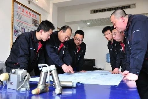 △李志強(qiáng)（左二）與班組成員在研究工作。