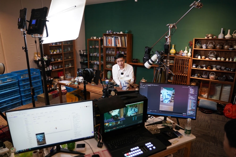 ↑在景德鎮(zhèn)，工作人員通過(guò)網(wǎng)絡(luò)直播推介陶瓷產(chǎn)品（2023年2月22日攝）。