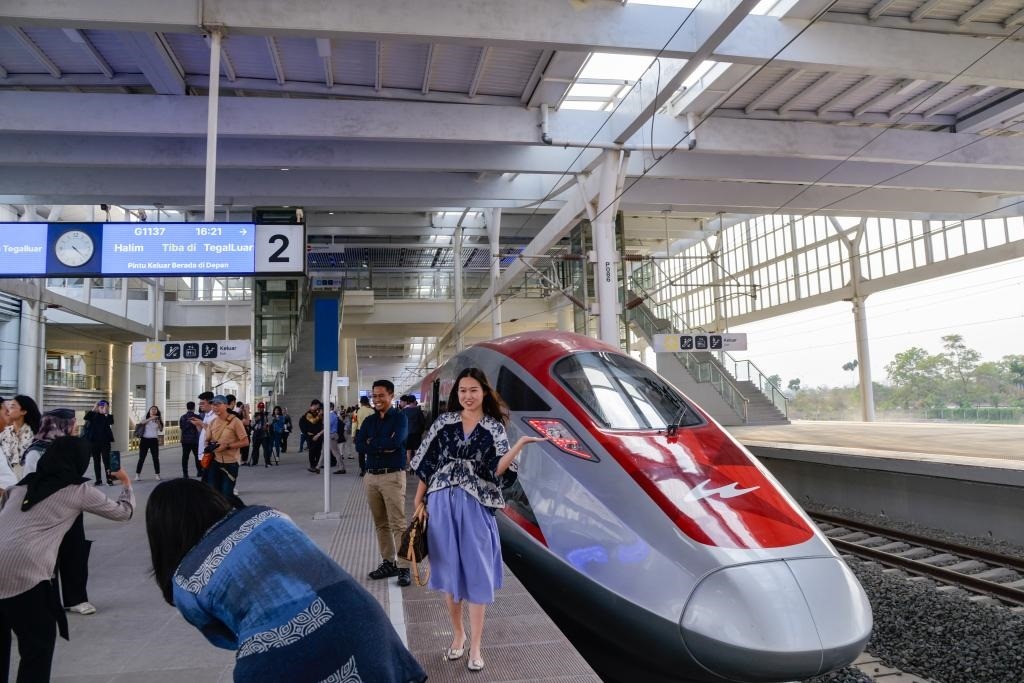 10月17日，在印度尼西亞萬隆德卡魯爾站，乘客在站臺上和雅萬高鐵高速動車組列車合影。