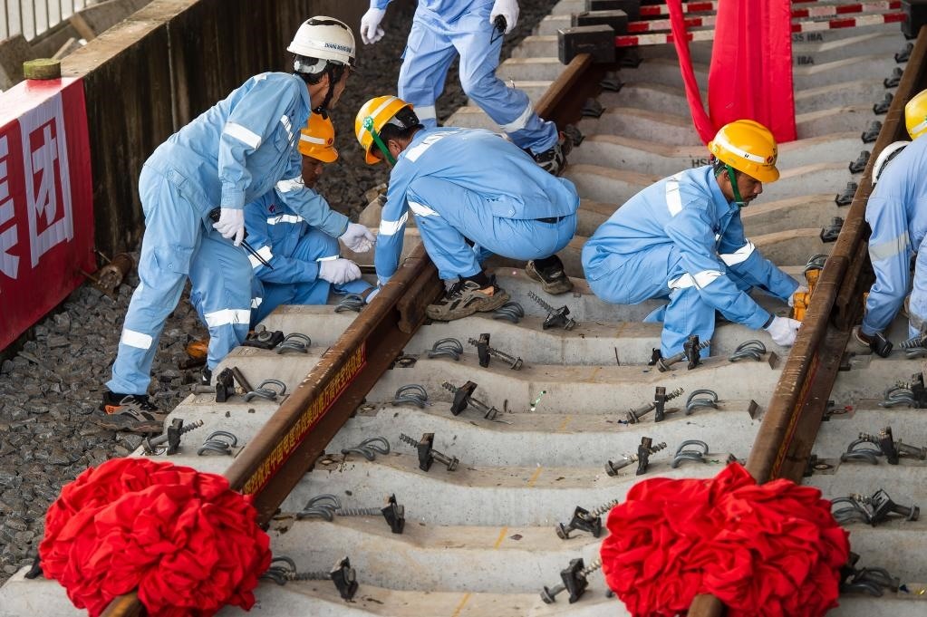 3月31日，在印度尼西亞雅加達(dá)雅萬高鐵哈利姆車站，工人鋪設(shè)雅萬高鐵全線最后一根鋼軌。