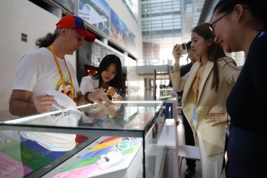 10月16日，參會記者在“一帶一路”國際合作高峰論壇新聞中心參觀展示的中國非物質文化遺產展品。新華社記者 陳斌 攝