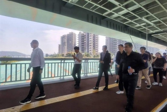 10月24日，2023“一帶一路”媒體合作論壇聯(lián)合采訪團(tuán)團(tuán)員走在清水塘大橋景觀通道上。本報(bào)記者 常雯宜攝