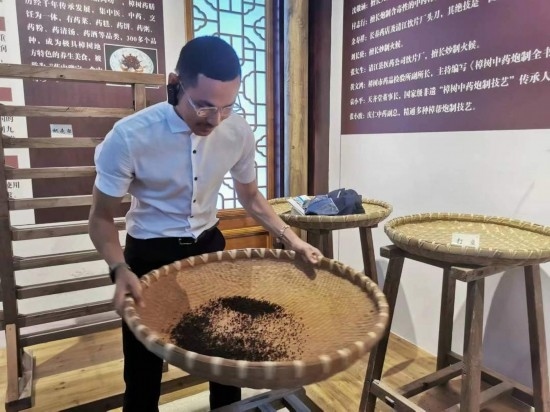 2023“一帶一路”媒體合作論壇聯(lián)合采訪(fǎng)團(tuán)團(tuán)員在非遺文化展示館體驗(yàn)中藥炮制技藝。（本報(bào)記者 黃超攝）