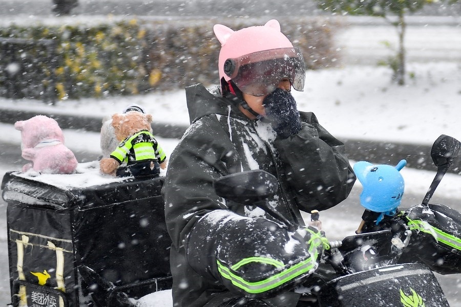 11月6日，在長春市街頭，一名外賣員在雪中騎行。新華社記者 許暢 攝