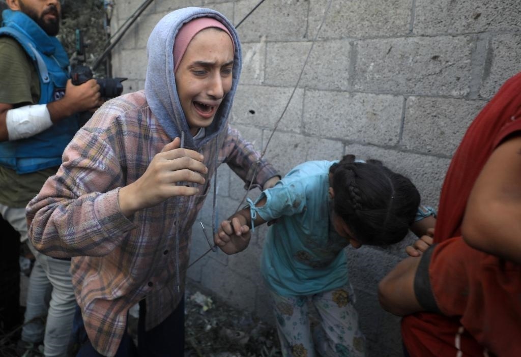 11月6日，人們從加沙地帶中部地區(qū)一處被炸難民營逃離。新華社發(fā)（亞西爾·庫迪攝）