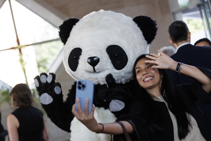2022年8月24日，在美國華盛頓中國駐美國大使館，來賓與大熊貓玩偶合影。