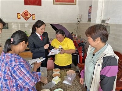  圖⑤：龍圩區(qū)法院法官到群眾家中開展法治宣傳。資料圖片