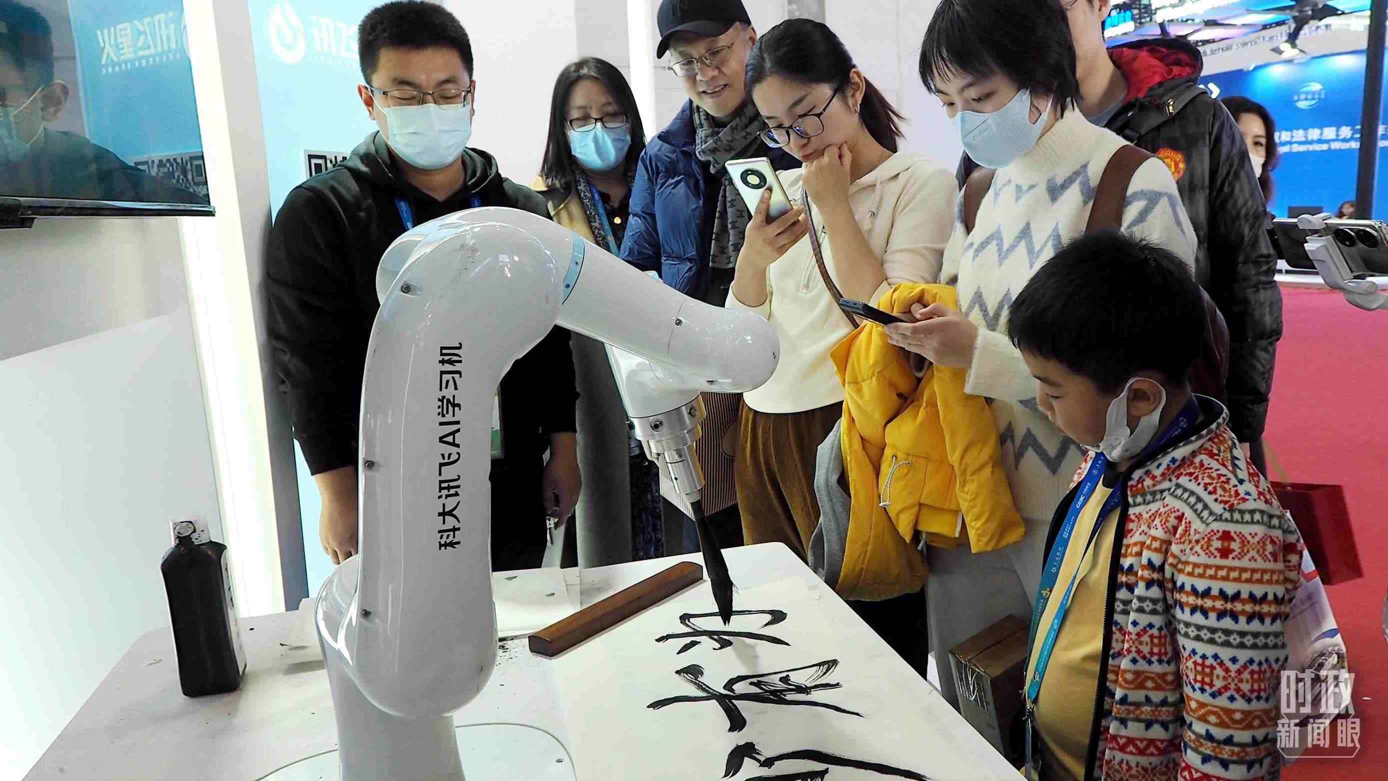 △觀眾在首屆鏈博會(huì)上體驗(yàn)AI書法機(jī)器人。