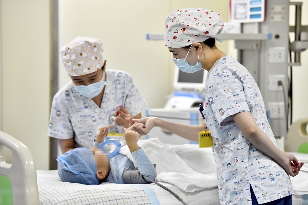 在山東省棗莊市婦幼保健院兒童ICU病房，醫(yī)護(hù)人員為完成靶向治療藥物諾西那生鈉的4歲脊髓性肌萎縮癥患兒加油鼓勁（2022年1月1日攝）。諾西那生鈉注射液是我國首個(gè)獲批治療脊髓性肌萎縮癥的進(jìn)口藥物，2019年進(jìn)入中國市場時(shí)，每針價(jià)格近70萬元。在2021年國家醫(yī)保目錄藥品談判中，以3.3萬元每針的價(jià)格進(jìn)入新版醫(yī)保藥品目錄。新華社記者 郭緒雷 攝