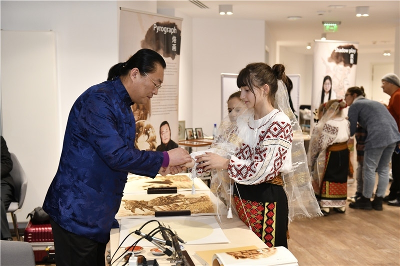 圖為羅馬尼亞小學(xué)生在現(xiàn)場體驗(yàn)烙畫。 布加勒斯特中國文化中心供圖