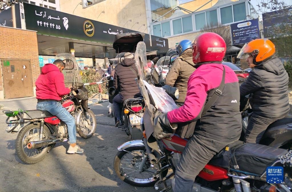 12月18日，摩托車在伊朗首都德黑蘭的一家加油站外等待加油。新華社記者 沙達(dá)提 攝