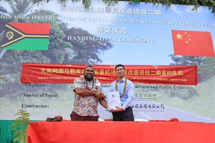 2023年12月18日，瓦努阿圖基礎(chǔ)設(shè)施和公共事業(yè)部長(zhǎng)瑞克·查馬克·馬赫（左）和中土南太公司總經(jīng)理梁慶（右）在馬勒庫(kù)拉諾索普機(jī)場(chǎng)升級(jí)改造二期項(xiàng)目的簽約儀式上握手。人民網(wǎng) 賀吉攝